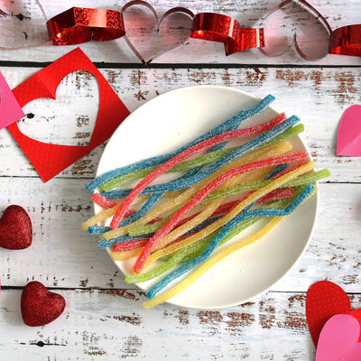 SOUR PUNCH Rainbow Straws Candy on a white plate surrounded by red heart cut outs