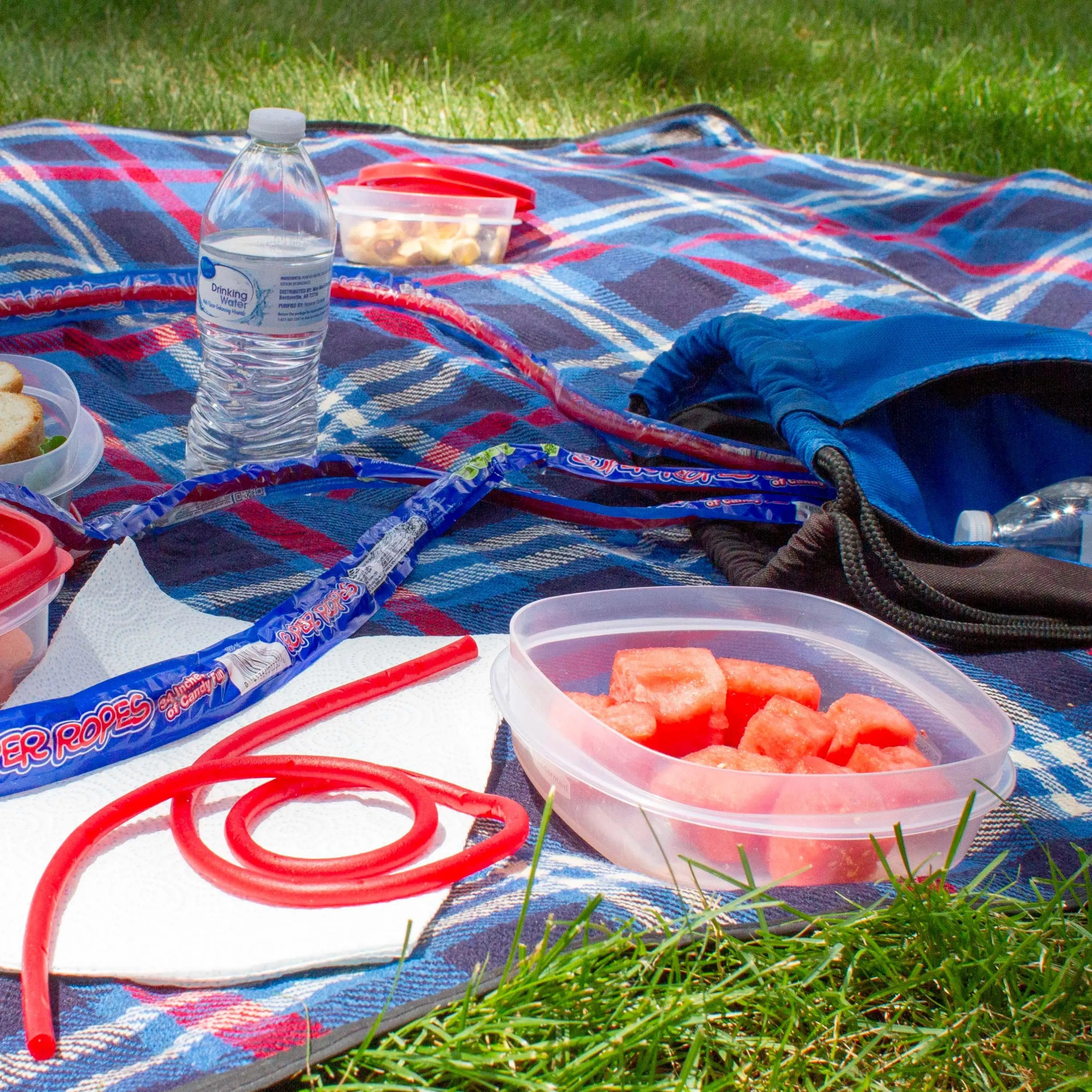 SUPER ROPES licorice on a blue picnic blanket with other picnic snacks