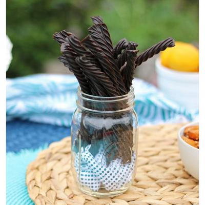 Red Vines Black Licorice Candy Twists in a jar near other poolside snacks