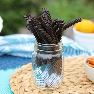 Red Vines Black Licorice Candy Twists in a jar near other poolside snacks