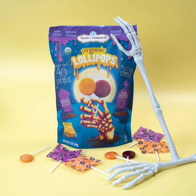 Organic Halloween Candy Lollipops with skeleton arms on a yellow background
