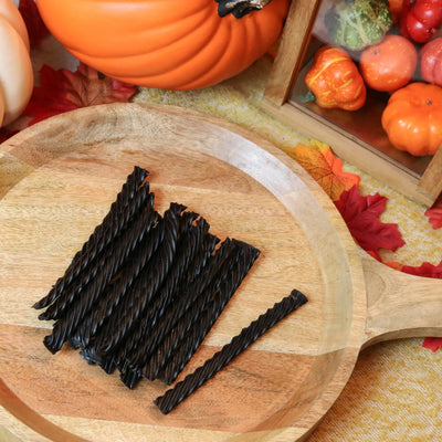 Red Vines Black Licorice Candy on a round wooden tray surrounded by pumpkins and leaves