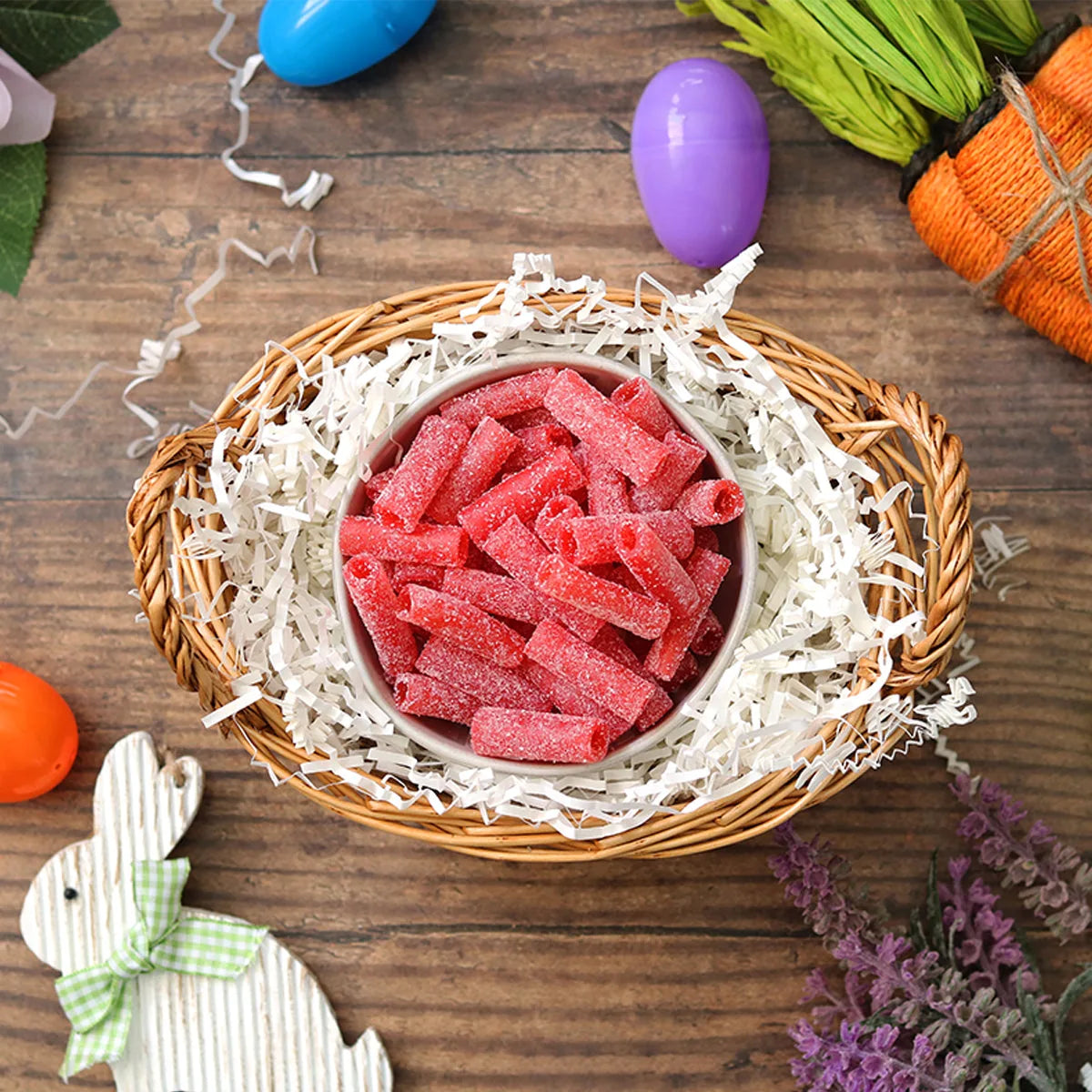 Sour Punch Strawberry Bites candy in an Easter basket  surrounded by confetti and plastic eggs