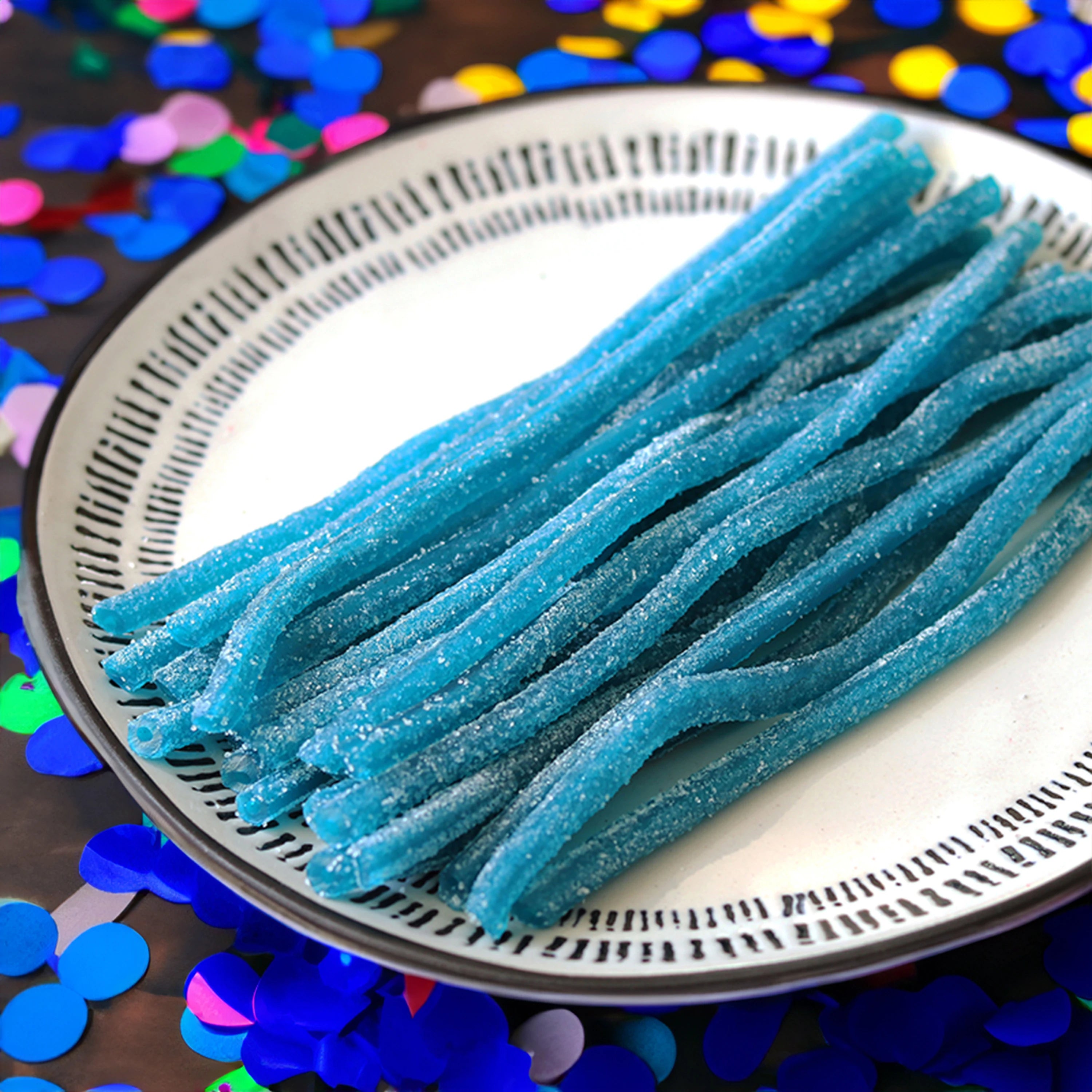 Sour Punch Blue Raspberry Candy Straws on a plate with colorful confetti in the background