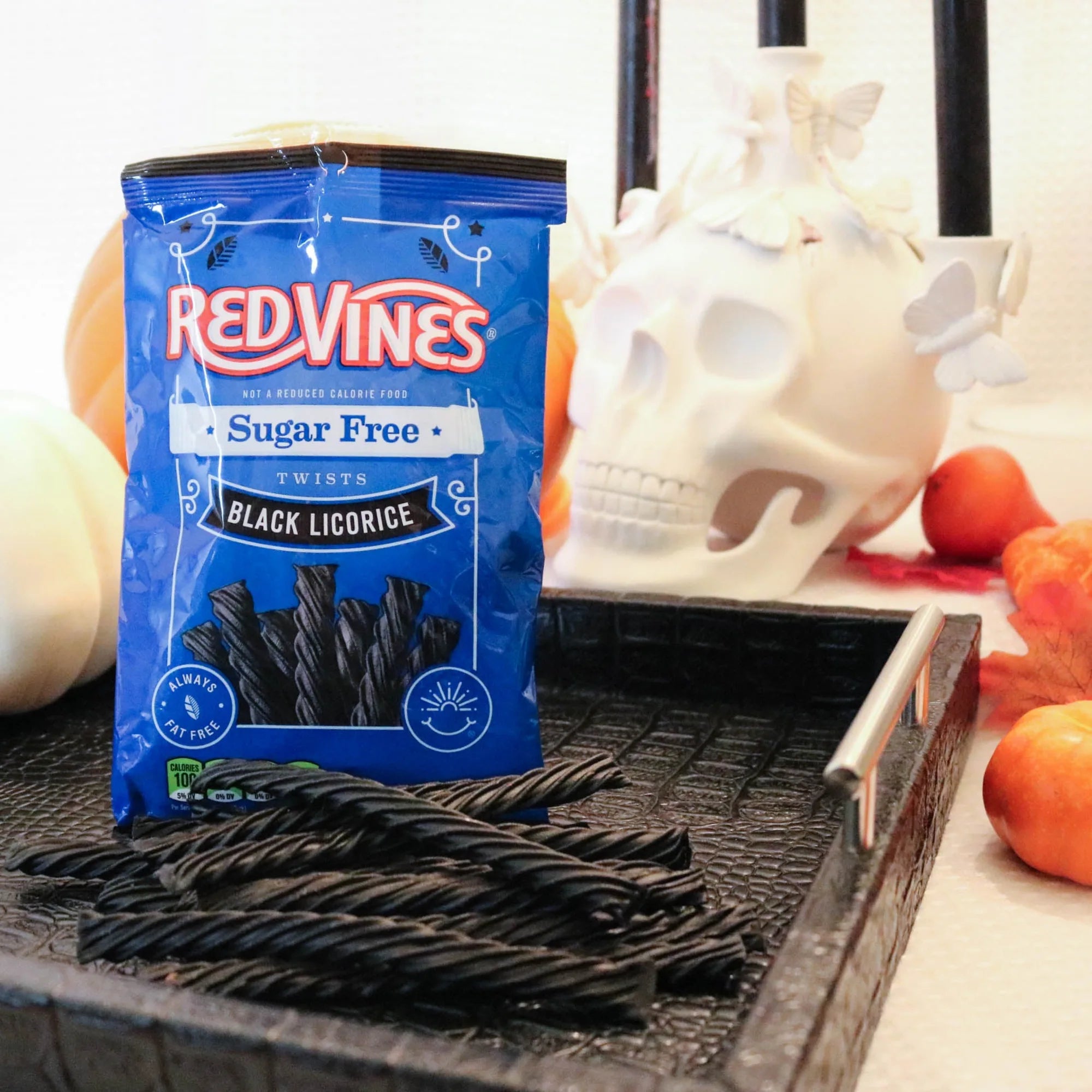 Red Vines Sugar Free Black Licorice Twists on a black platter with pumpkins and fake skulls