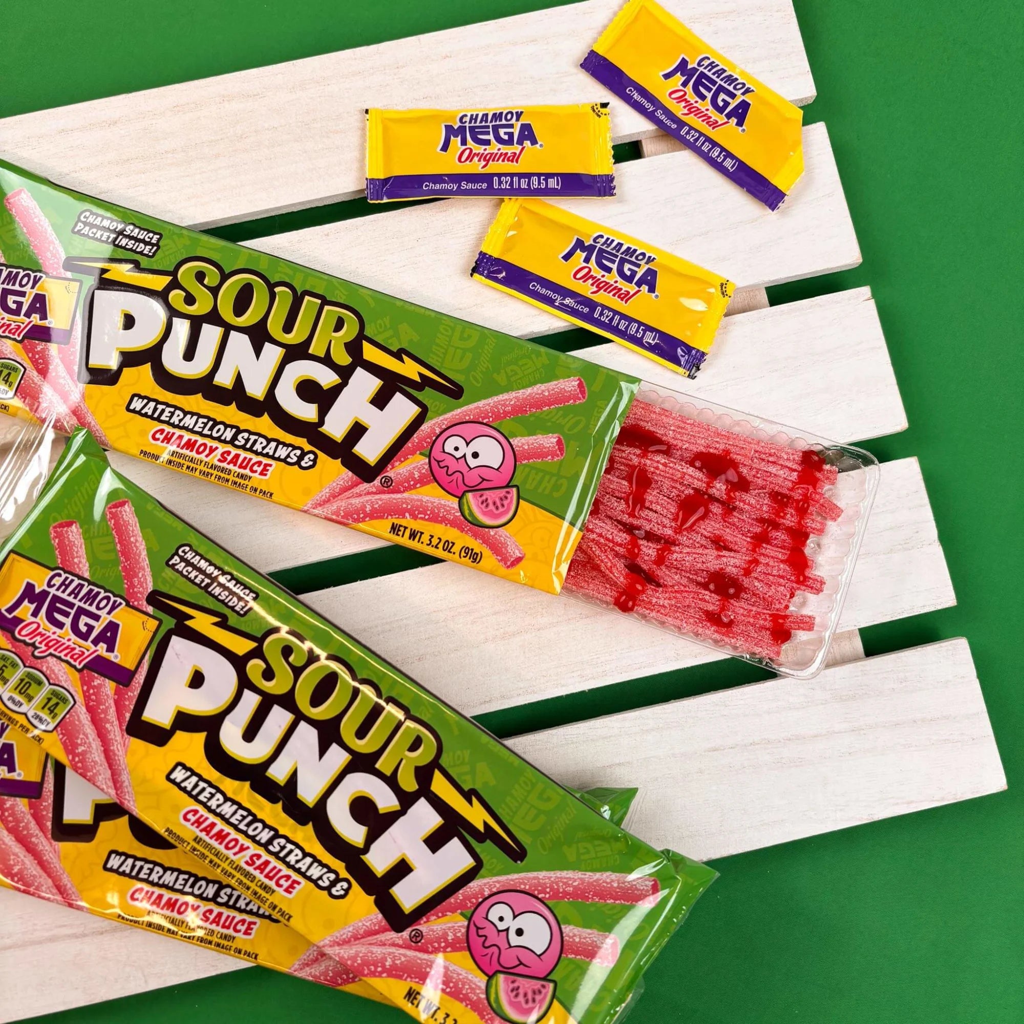 Open Sour Punch Tray with Chamoy Sauce drizzled over Watermelon candy straws