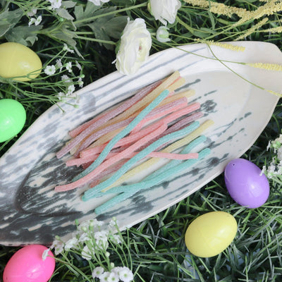 SOUR PUNCH Easter Candy Straws on a platter surrounded by plastic Easter eggs