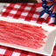 Sour Punch Strawberry Straws Candy on a picnic table with patriotic decorations