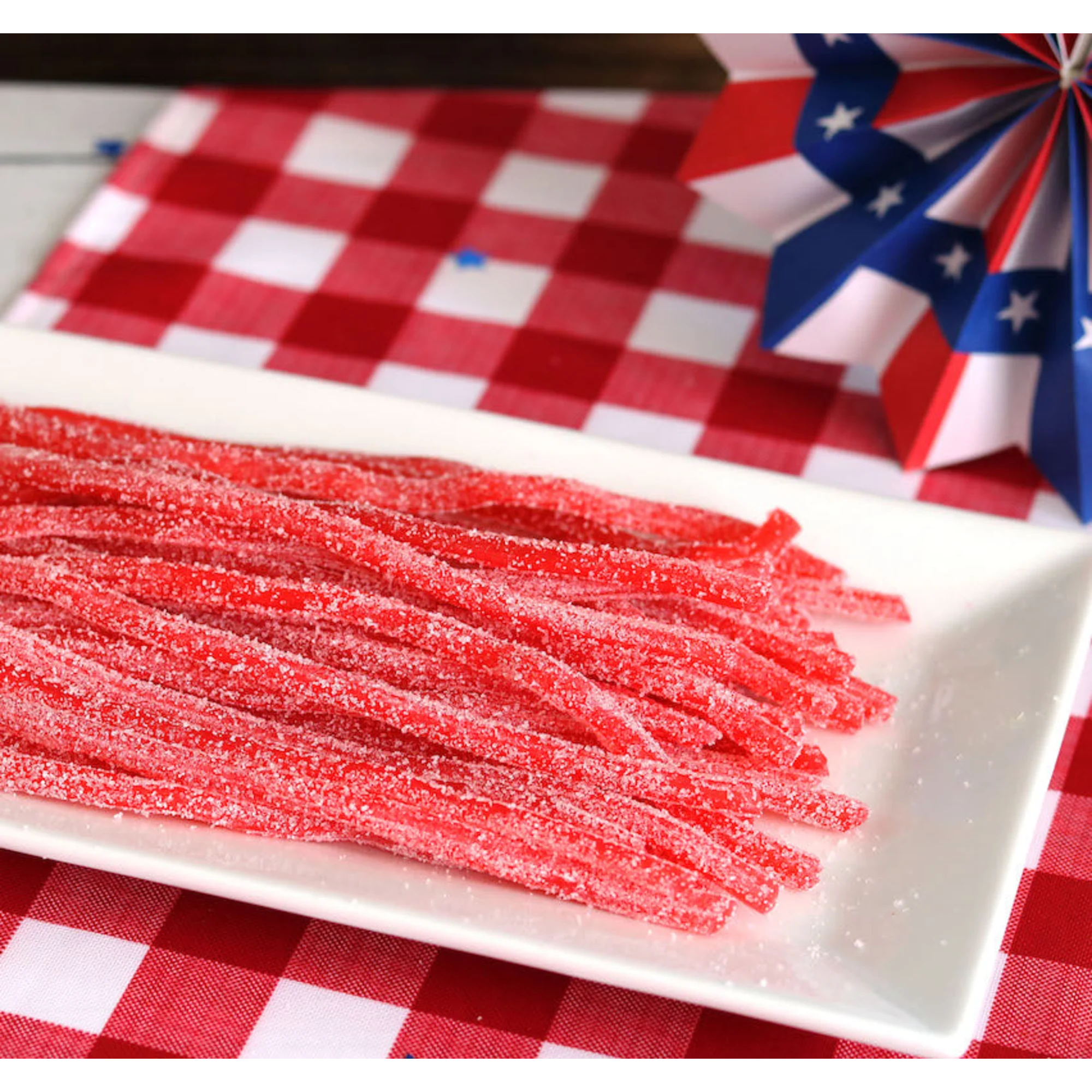 Sour Punch Strawberry Straws Candy on a picnic table with patriotic decorations