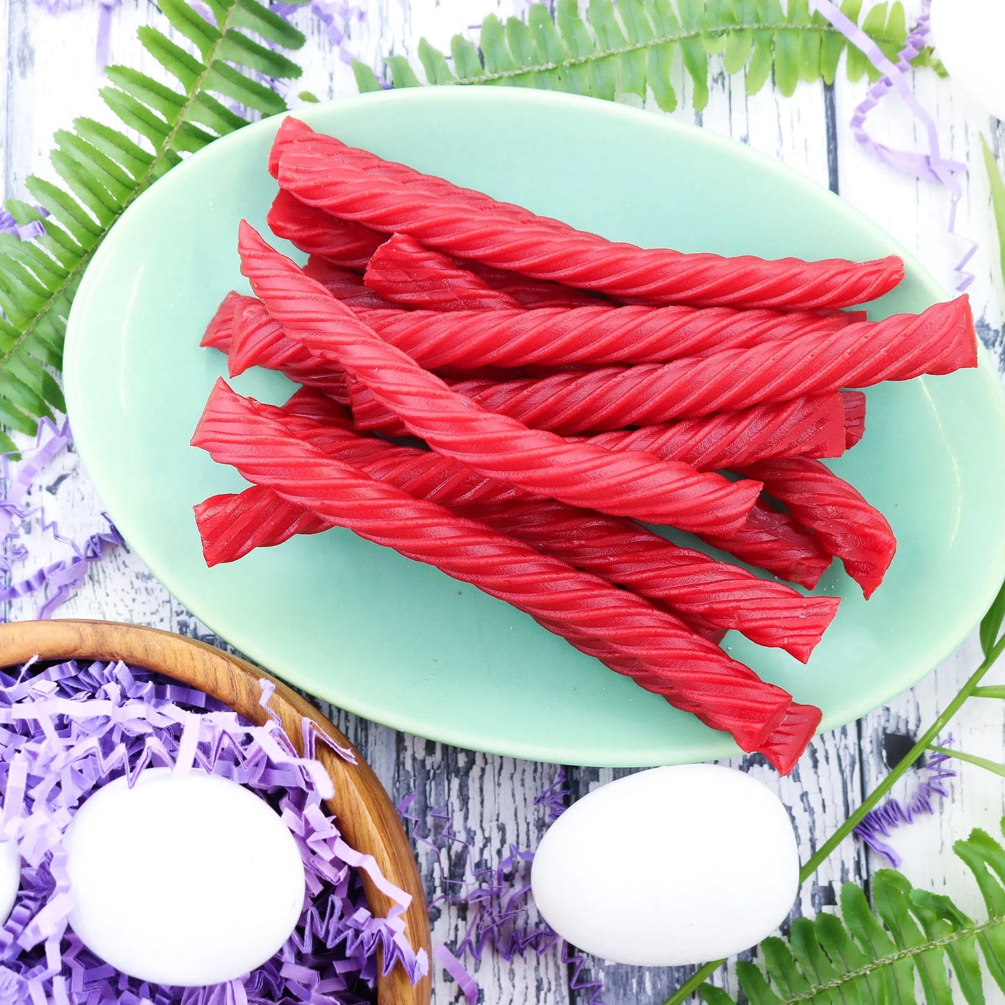 Red Vines Original Red Jumbo Licorice Twists on a picnic table with eggs and confetti