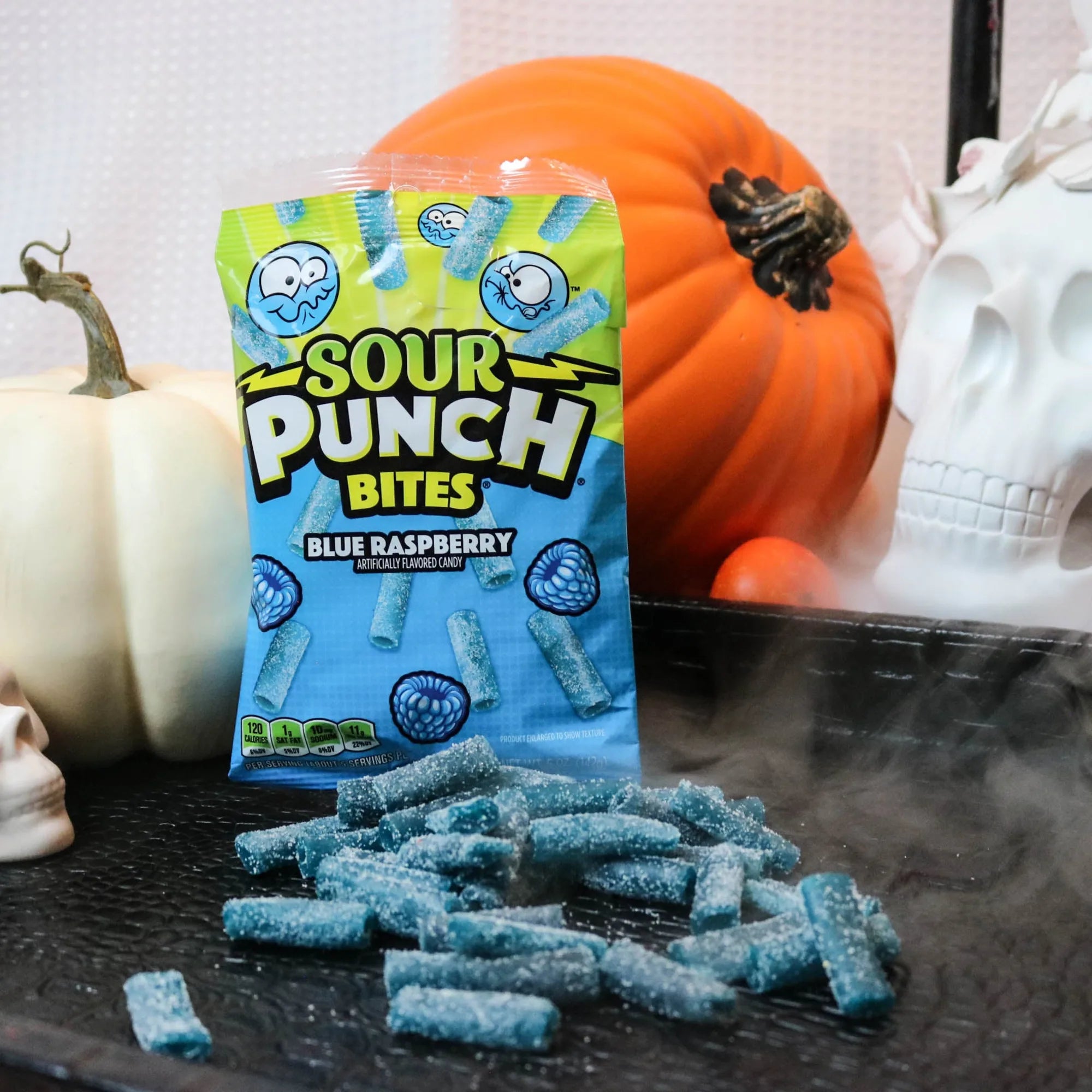 Sour Punch Blue Raspberry Bites Candy on a black tray with pumpkins and fake skulls