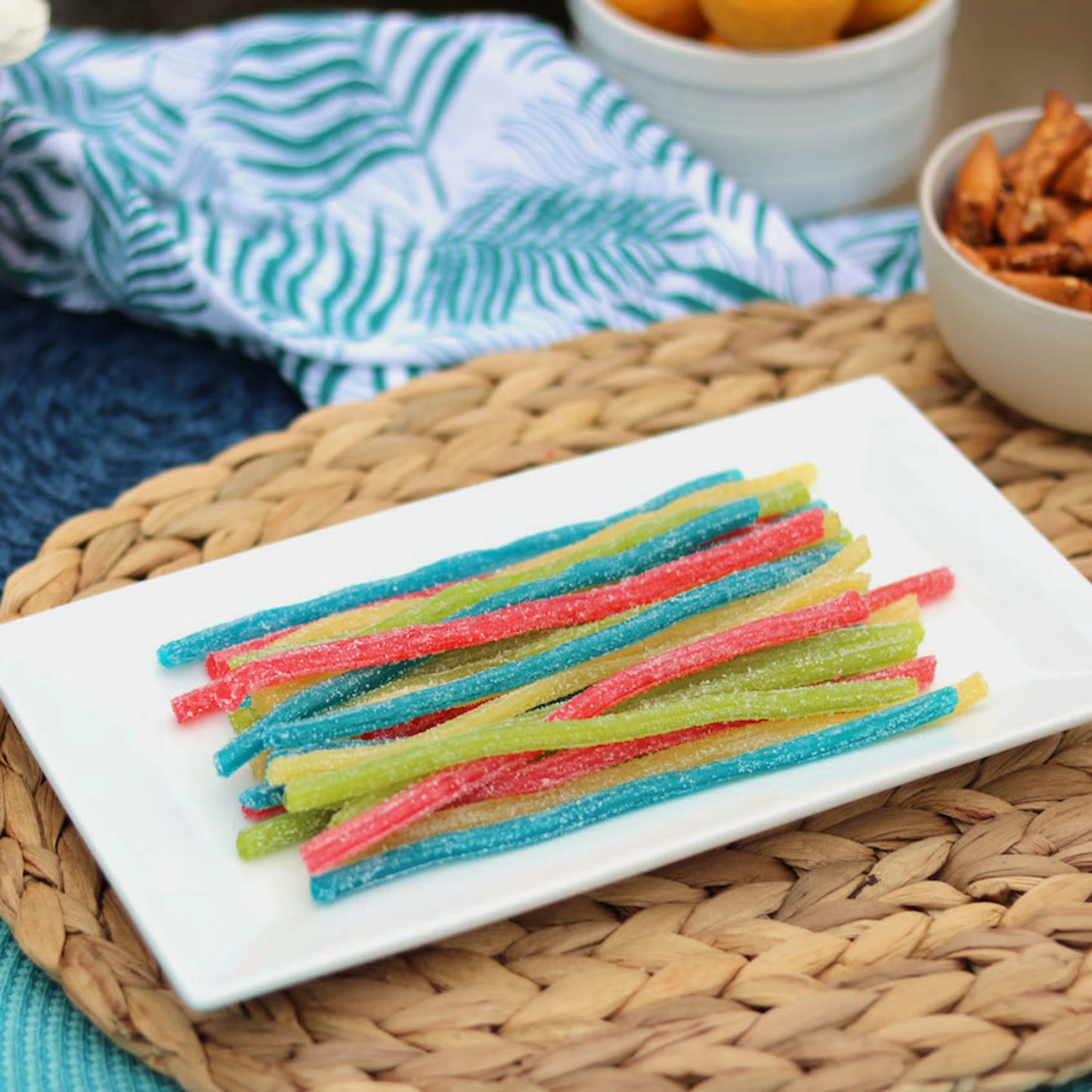 Sour Punch Rainbow Sour Candy Straws on a platter near other poolside snacks