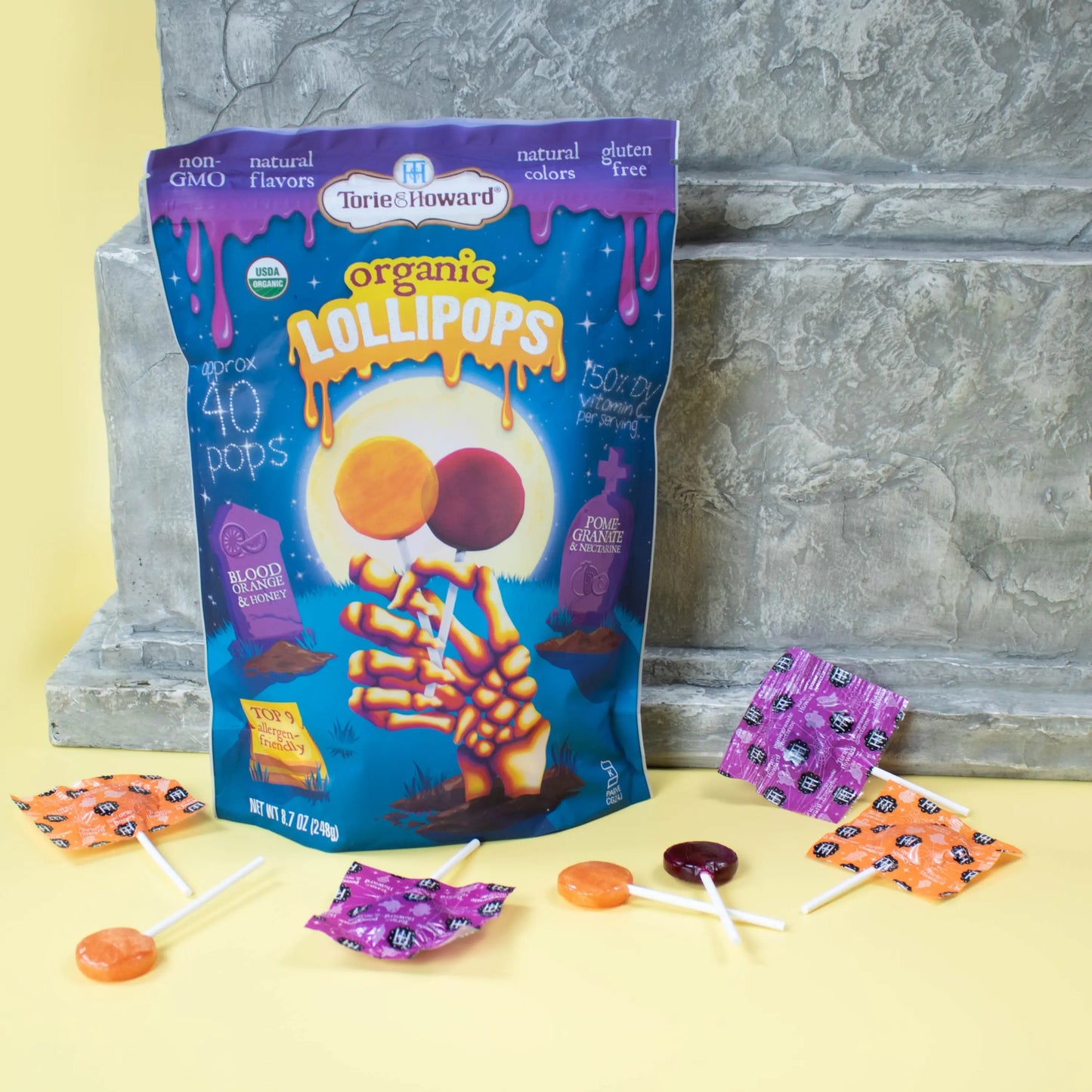 Organic Halloween Candy Lollipops in front of a tombstone