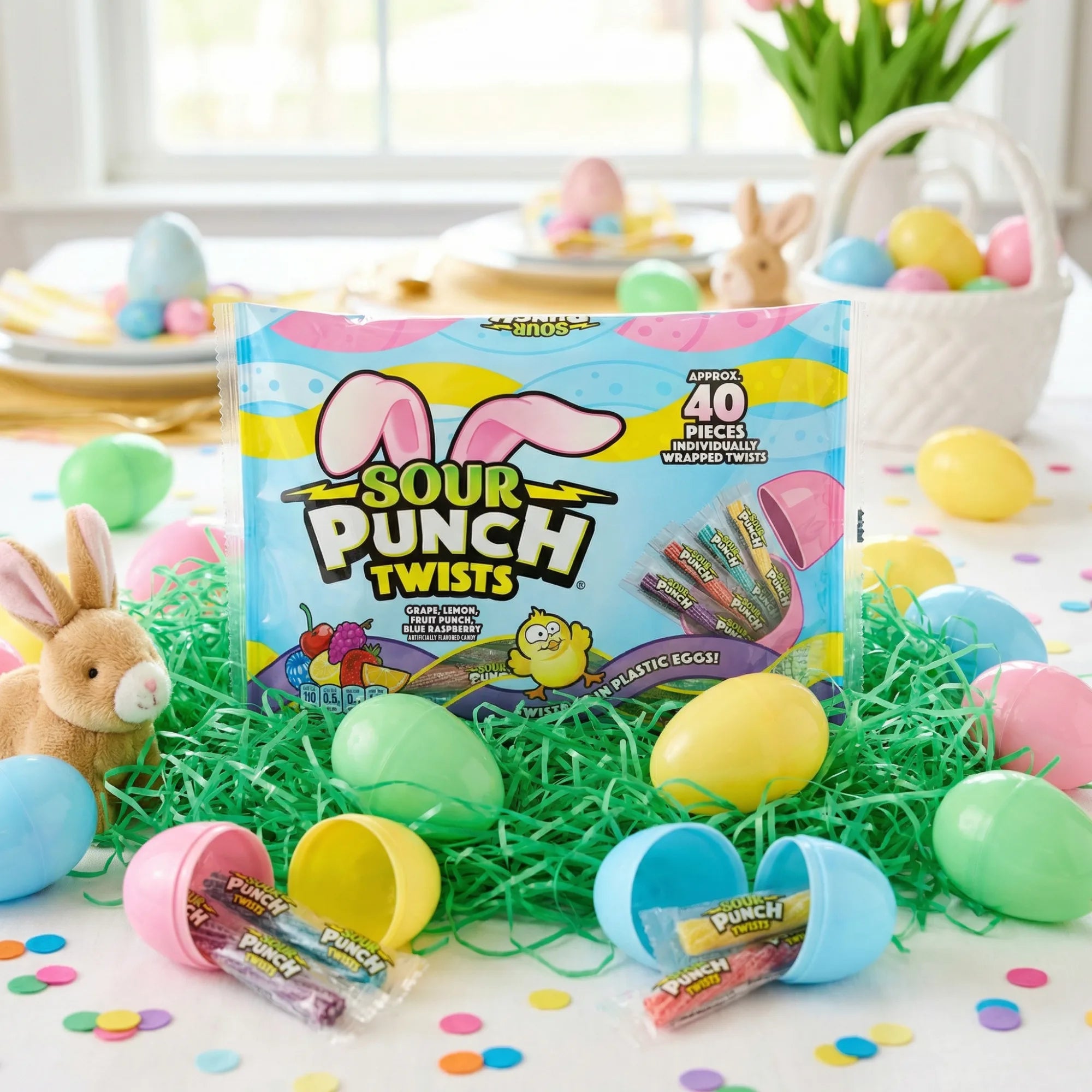 Sour Punch Easter Twists candy in a scene with grass confetti, plastic Easter eggs, real dyed eggs, and a stuffed bunny