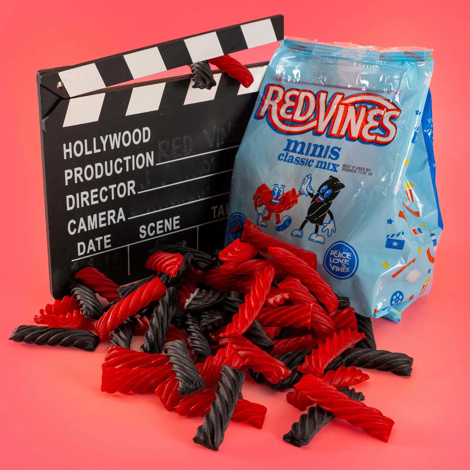 Red Vines Classic Mix Minis Bag next to a film clapperboard with mini black and red licorice in front
