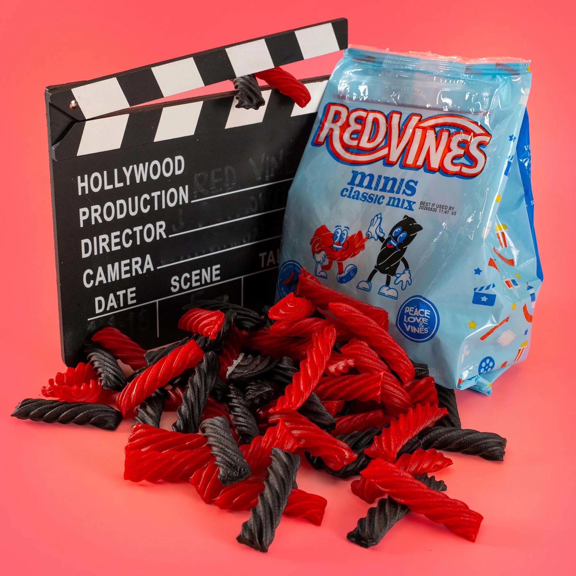 Red Vines Classic Mix Minis Bag next to a film clapperboard with mini black and red licorice in front