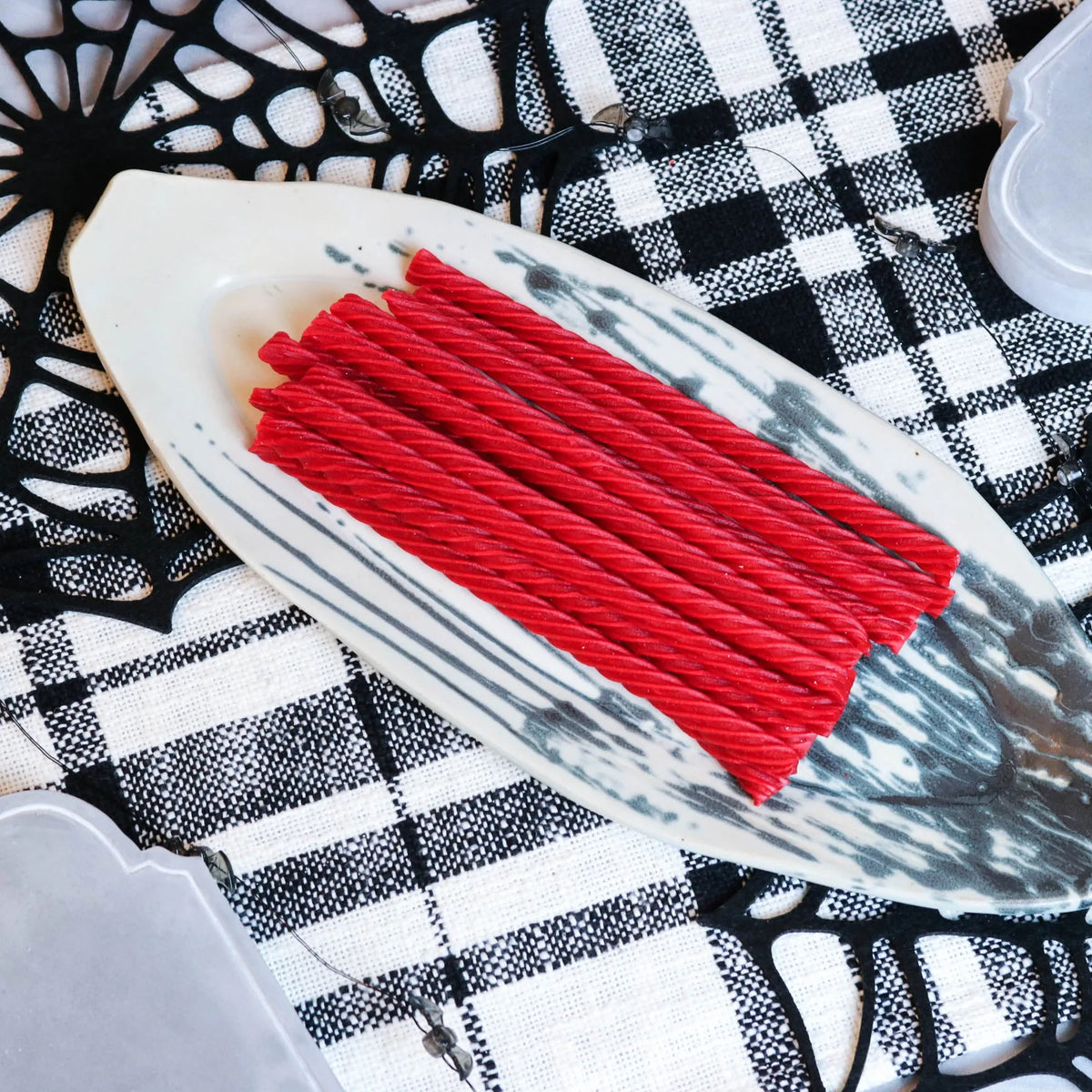 Red Vines Original Red Licorice Candy on a platter with a fake spiderweb and tombstone