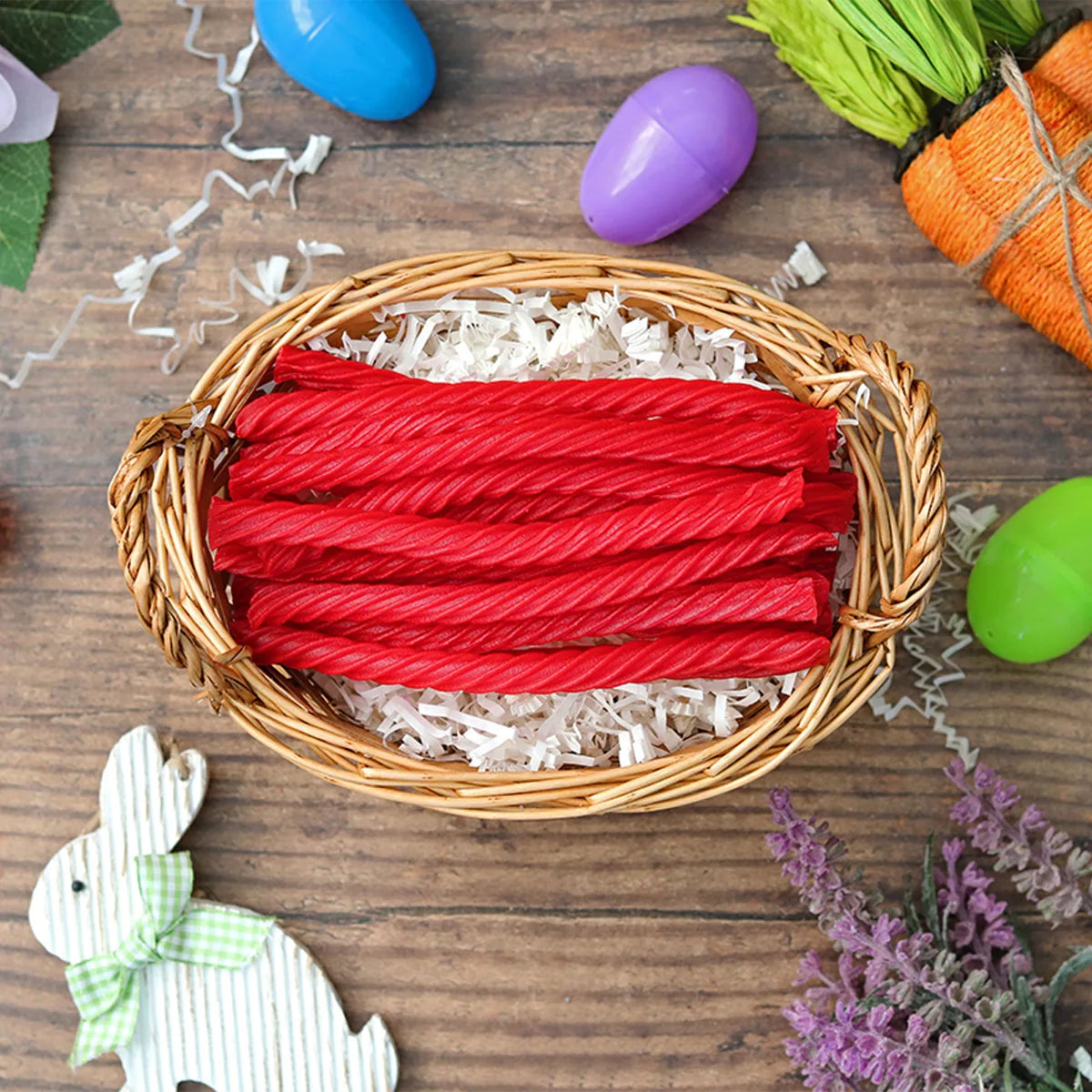 Red Vines Original Red Licorice Twists candy in an Easter basket  surrounded by confetti and plastic eggs