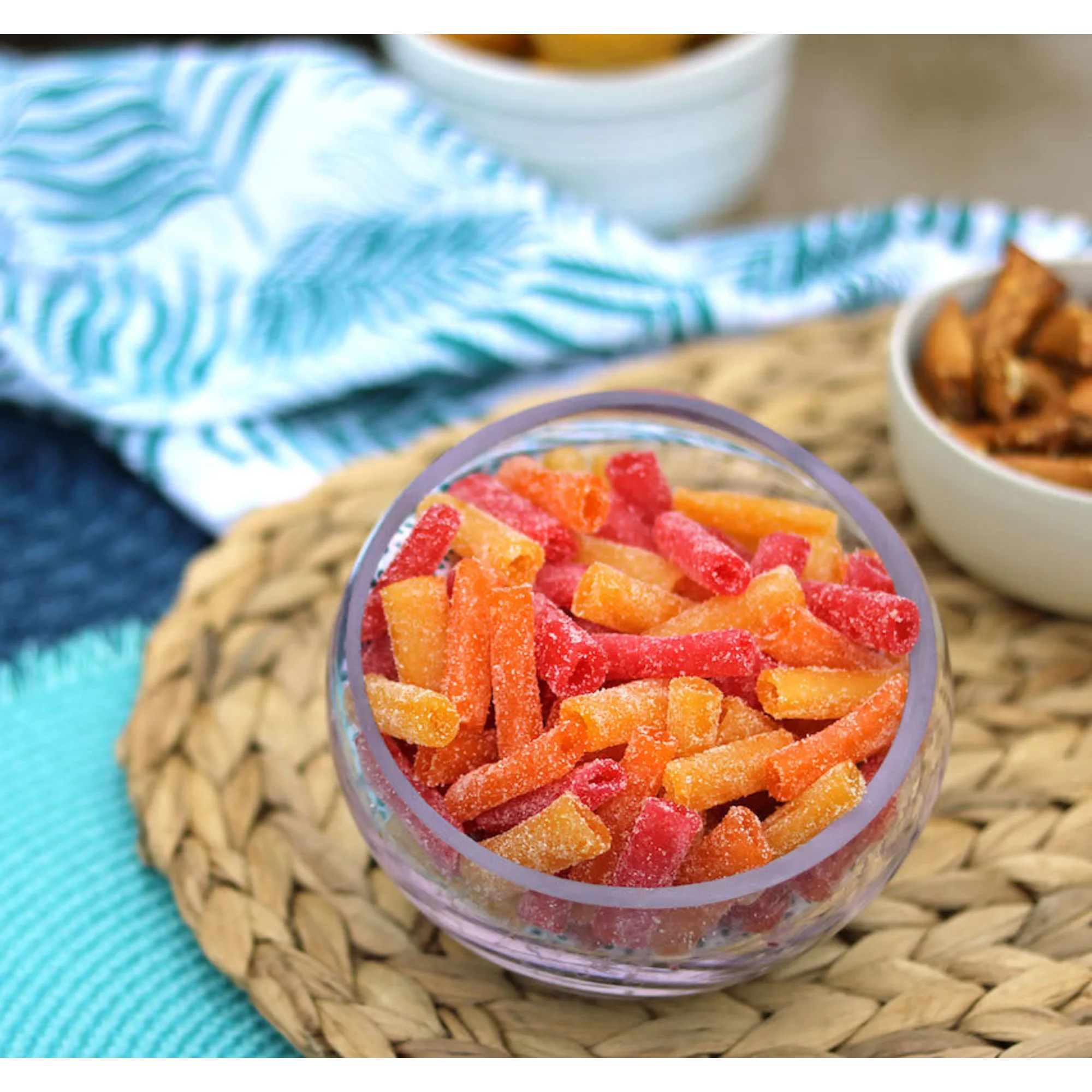 Sour Punch Bites Tropical Flavors in a bowl near other poolside snacks
