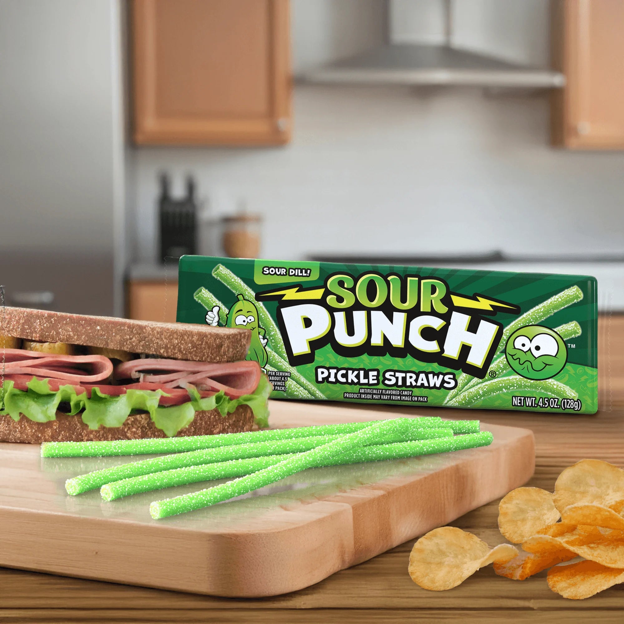 Sour Punch Pickle Straws on a kitchen counter with a sandwich and chips.