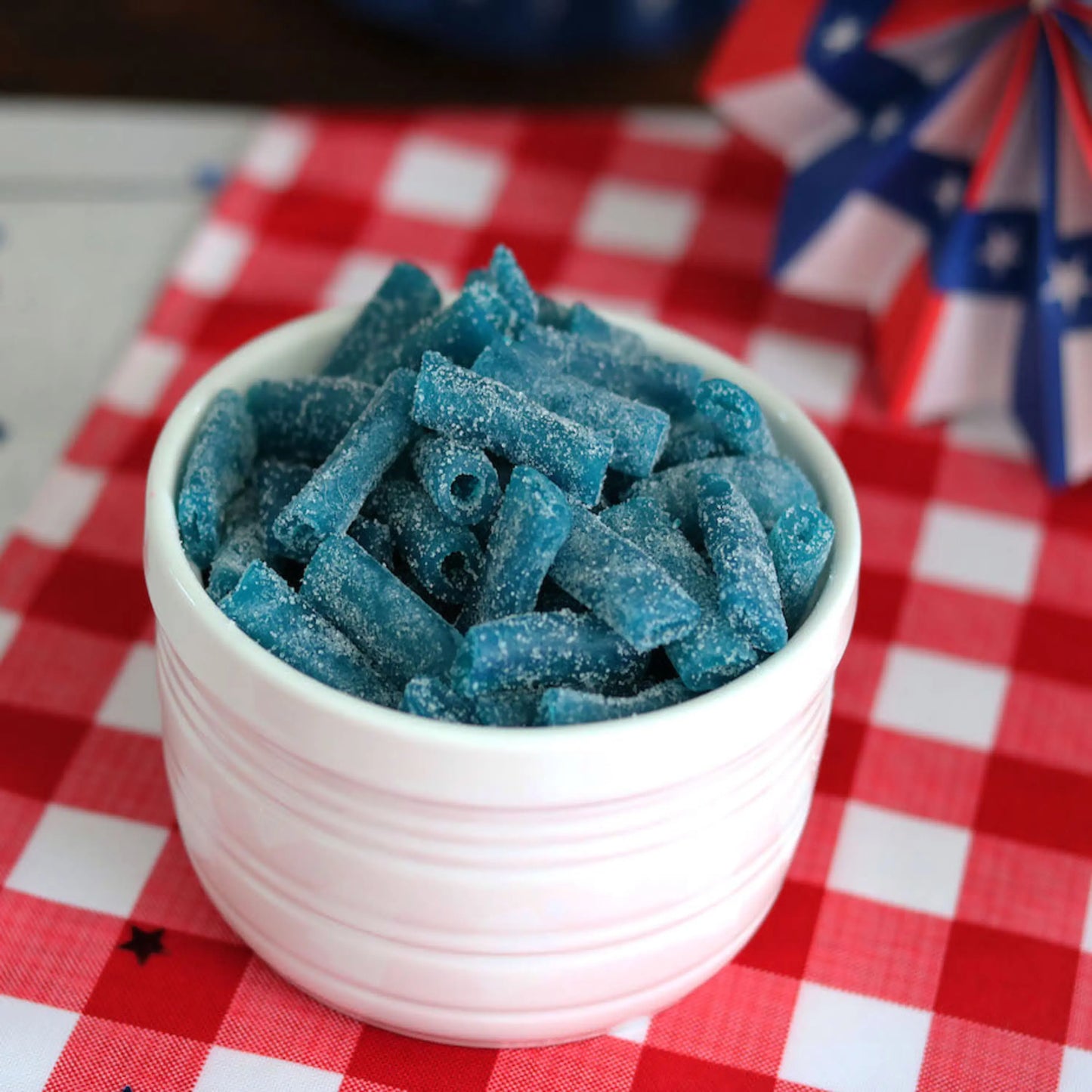 Sour Punch Bites Blue Raspberry Candy on a picnic table with patriotic decorations