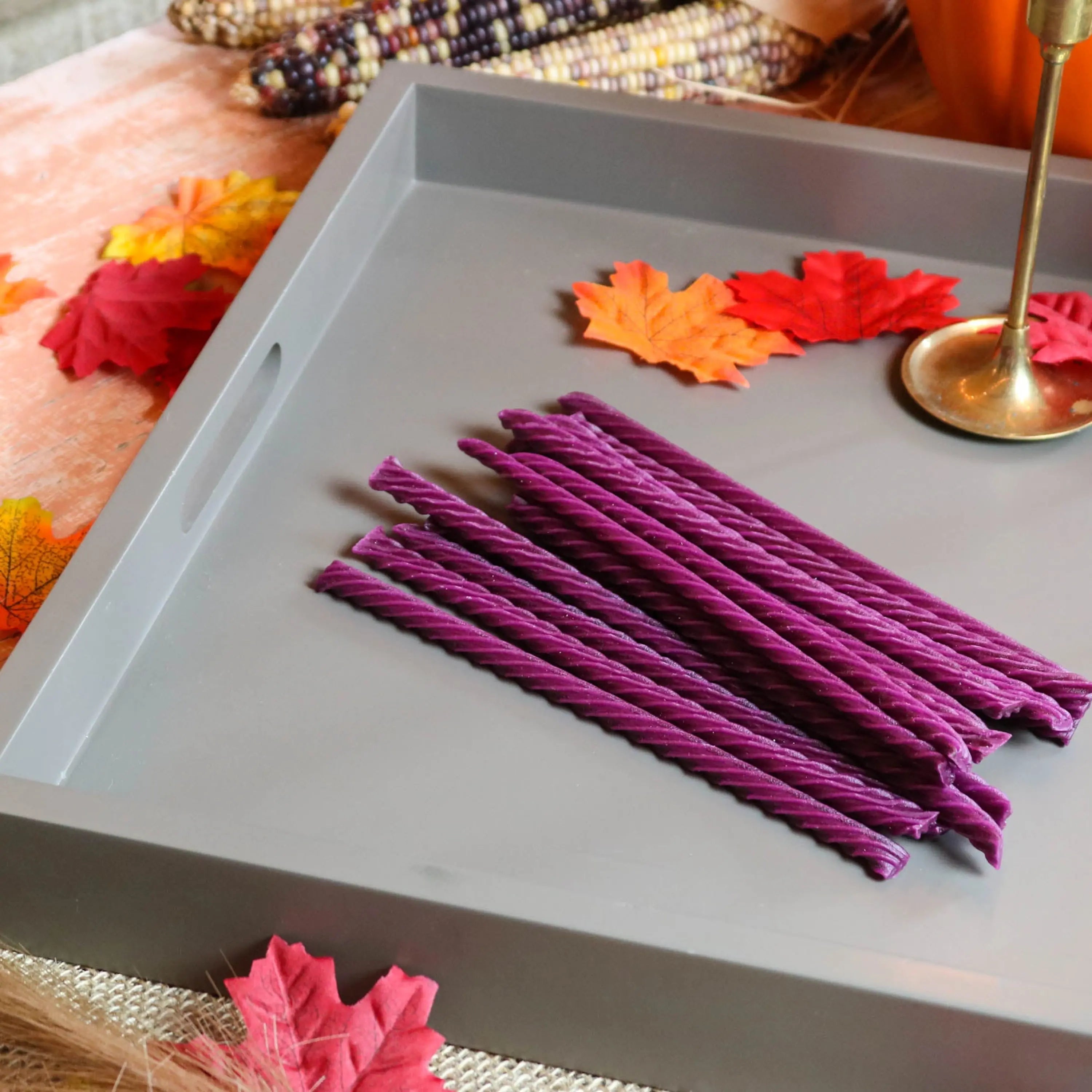 Red Vines Grape Licorice Candy on a gray serving tray with leaves and falltime props