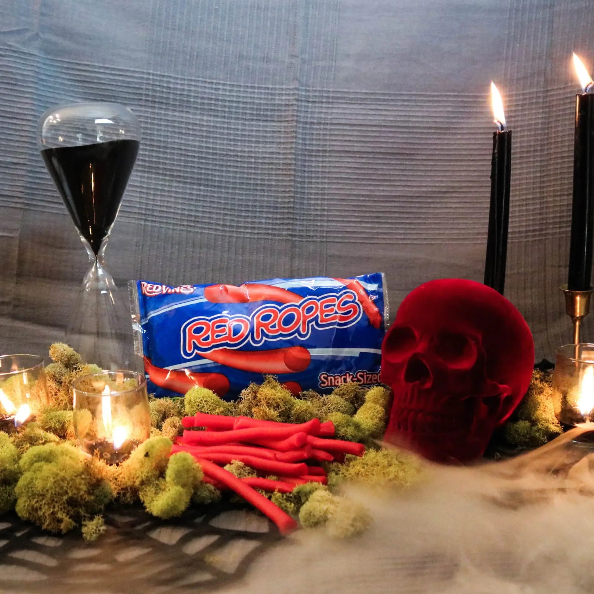 Red Ropes Licorice Rope Candy on moss with a fake skull and candles