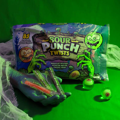 Sour Punch Individually Wrapped Halloween Candy Twists in a spooky scene with eyeballs and a monster hand