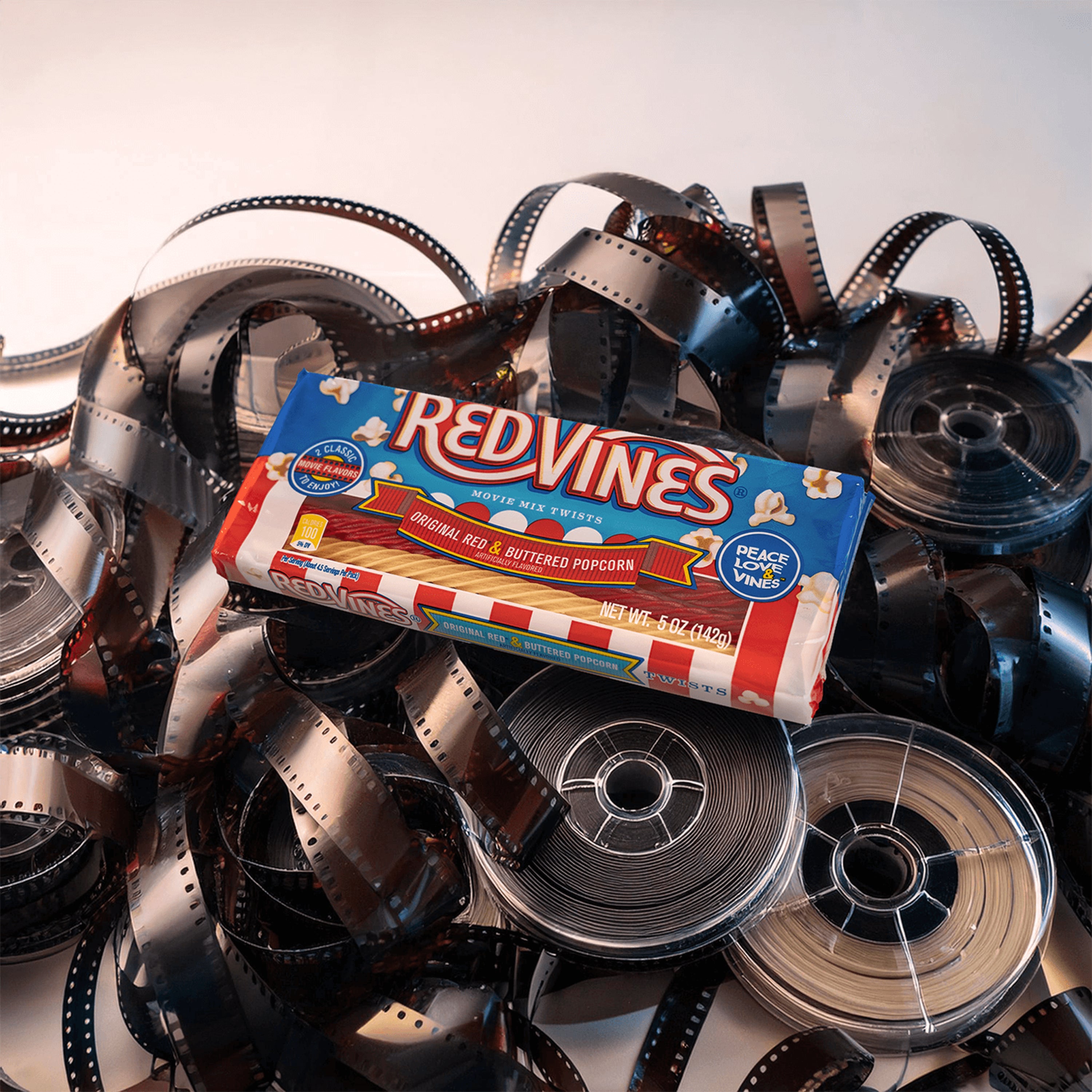 Red Vines Buttered Popcorn & Original Red Twists on a pile of movie film reels