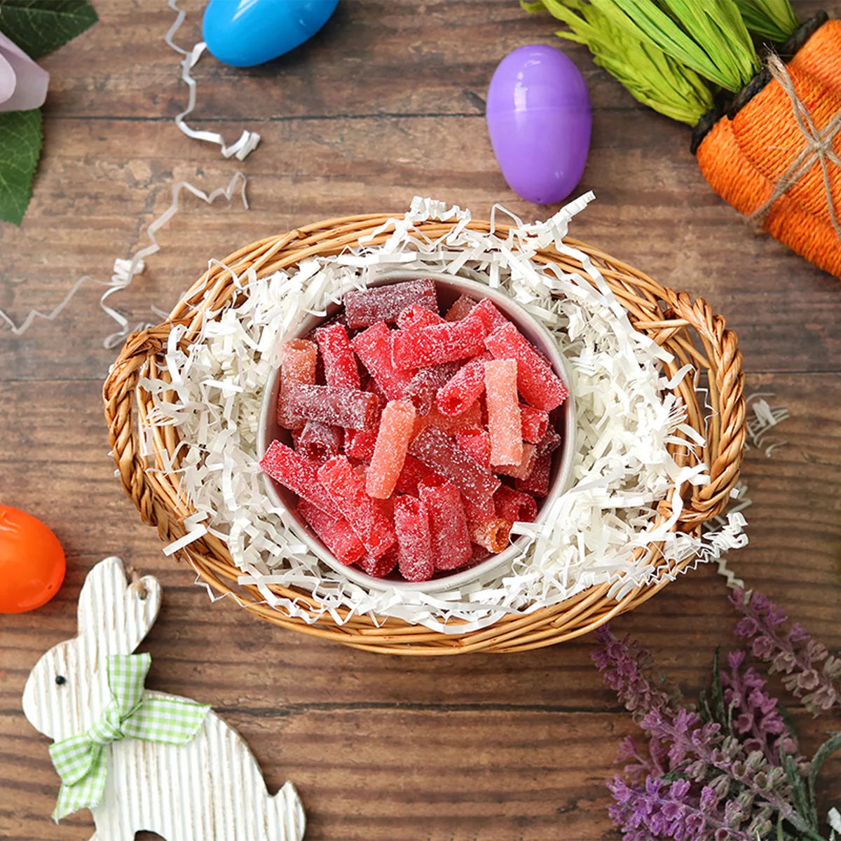 Sour Punch Rad Reds Bites candy in an Easter basket  surrounded by confetti and plastic eggs