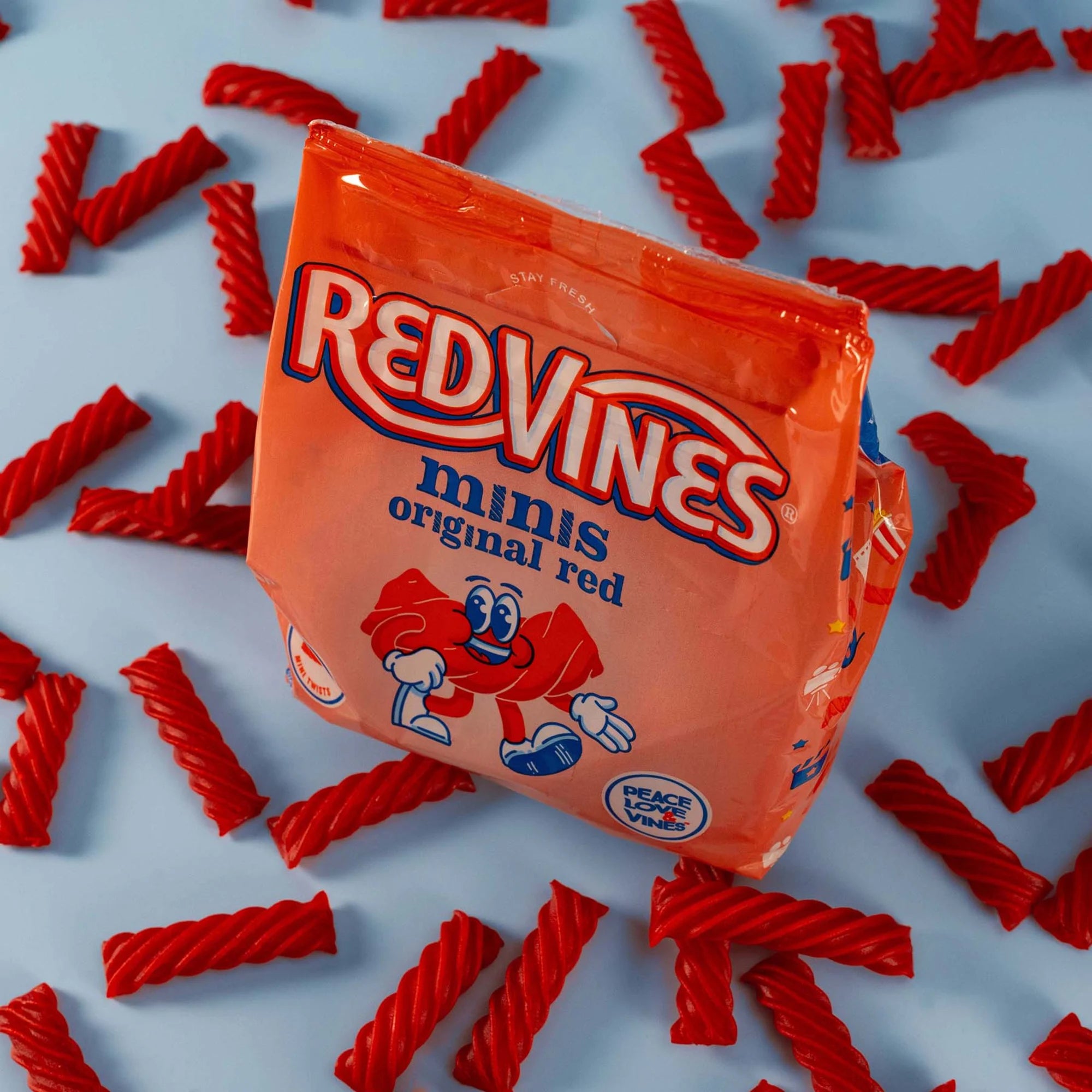 Red Vines Original Red Minis Bag surrounded by mini red licorice pieces
