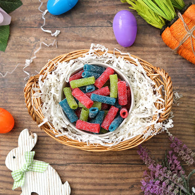 Sour Punch Assorted Bites candy in an Easter basket  surrounded by confetti and plastic eggs