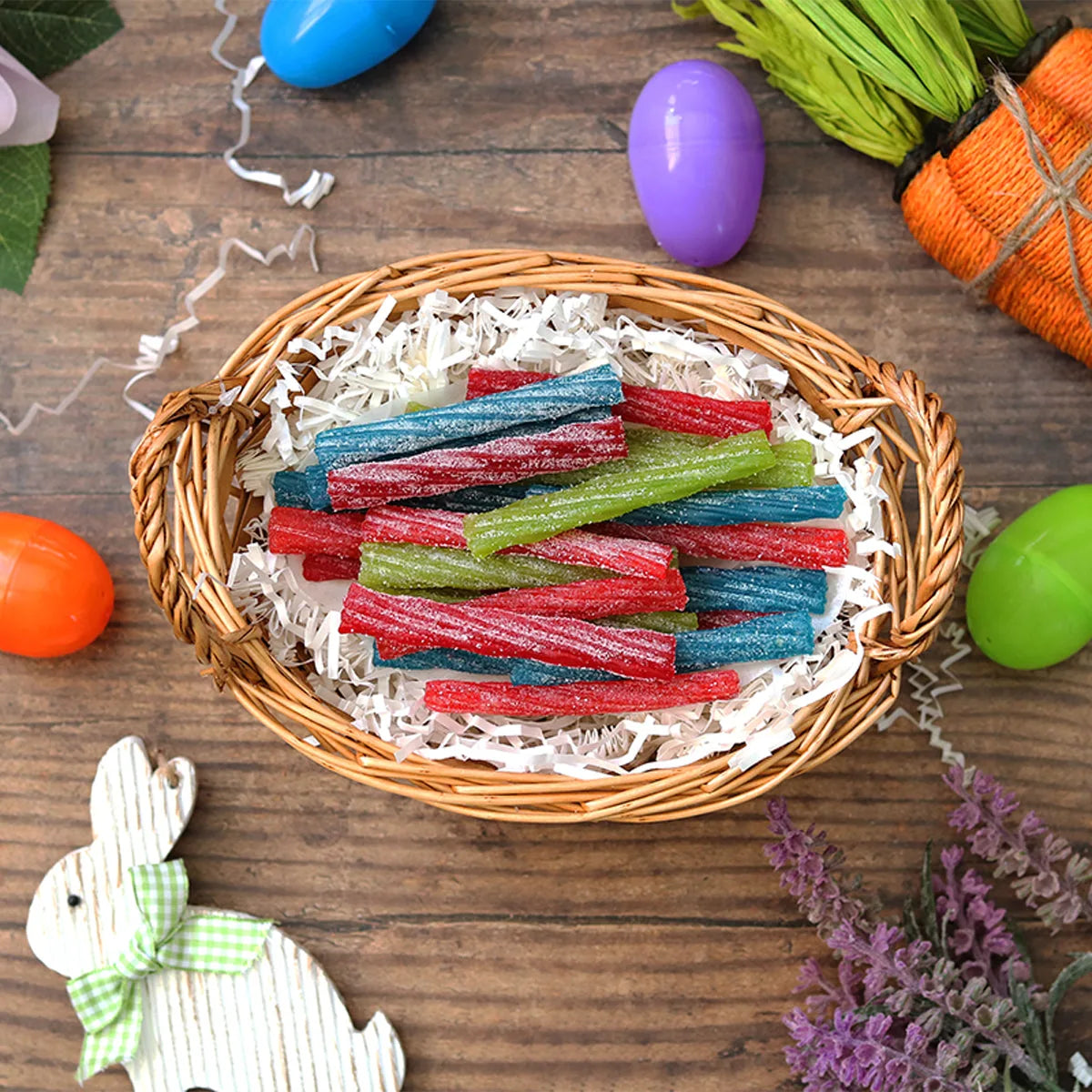 Sour Punch Individually Wrapped Candy Twists in an Easter basket surrounded by confetti and plastic eggs