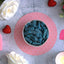 SOUR PUNCH Blue Raspberry Candy Bites in a bowl surrounded by hearts and roses