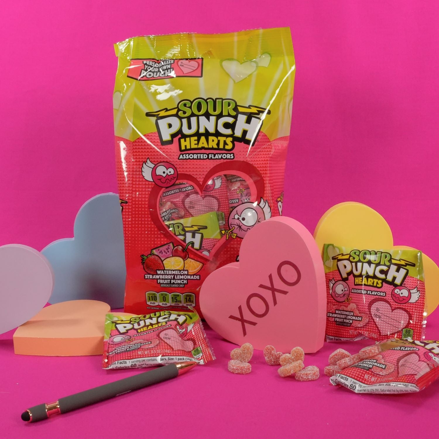 SOUR PUNCH Hearts valentine candy on hot pink background with heart props and a pen