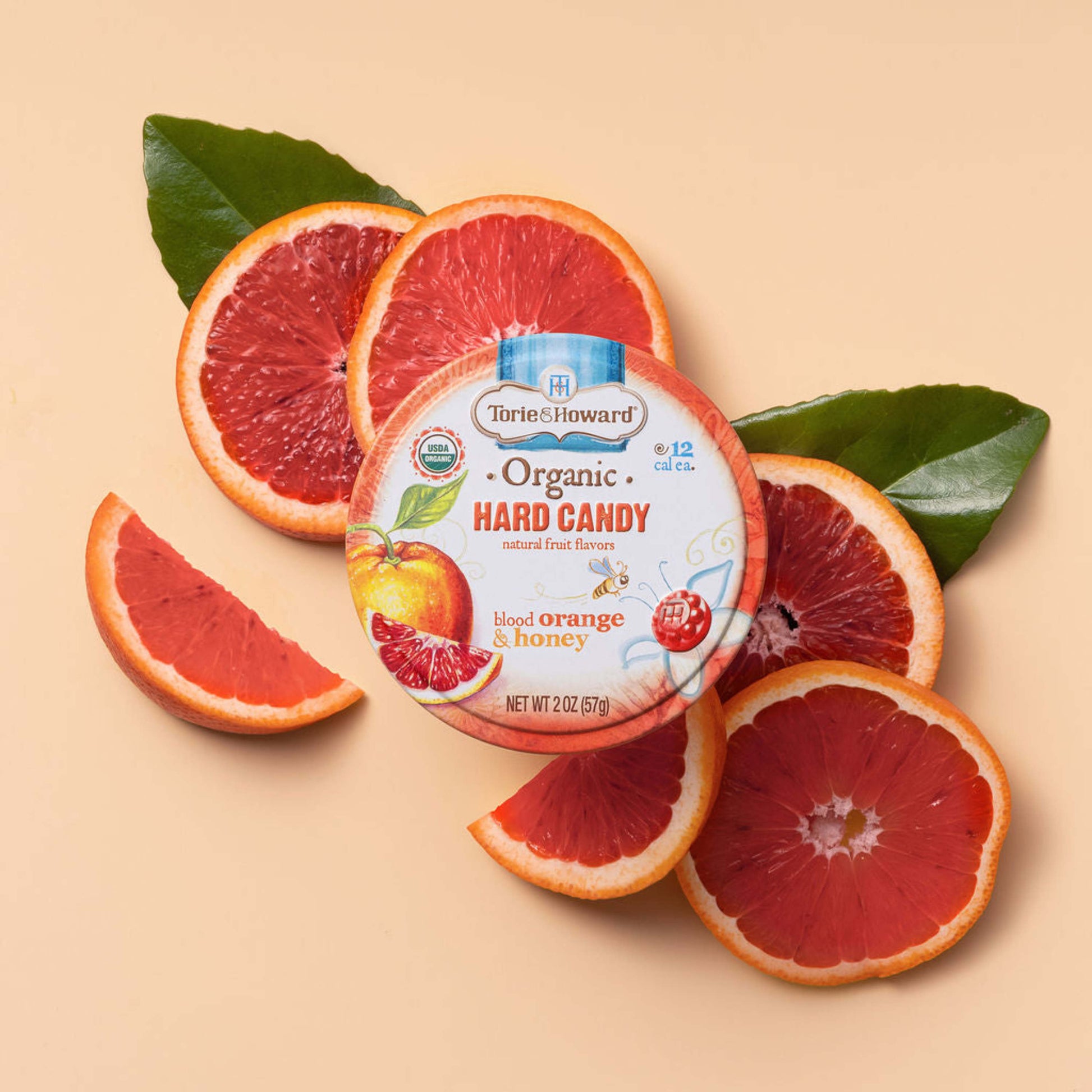 Torie & Howard Blood Orange & Honey Organic Hard Candy 2oz tin on juicy oranges