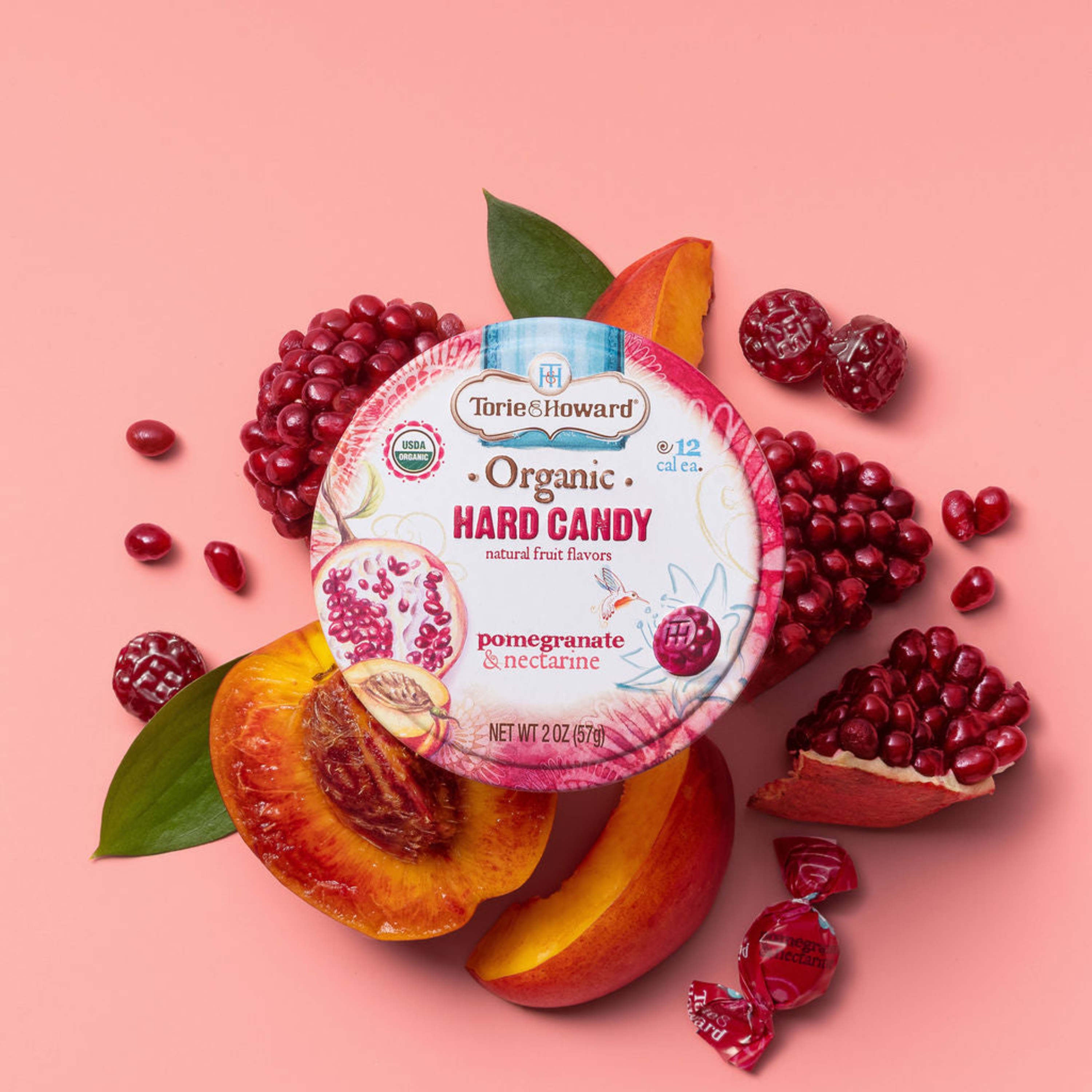 Torie & Howard Pomegranate & Nectarine Organic Hard Candy 2oz Tin on fresh fruit with candy pieces
