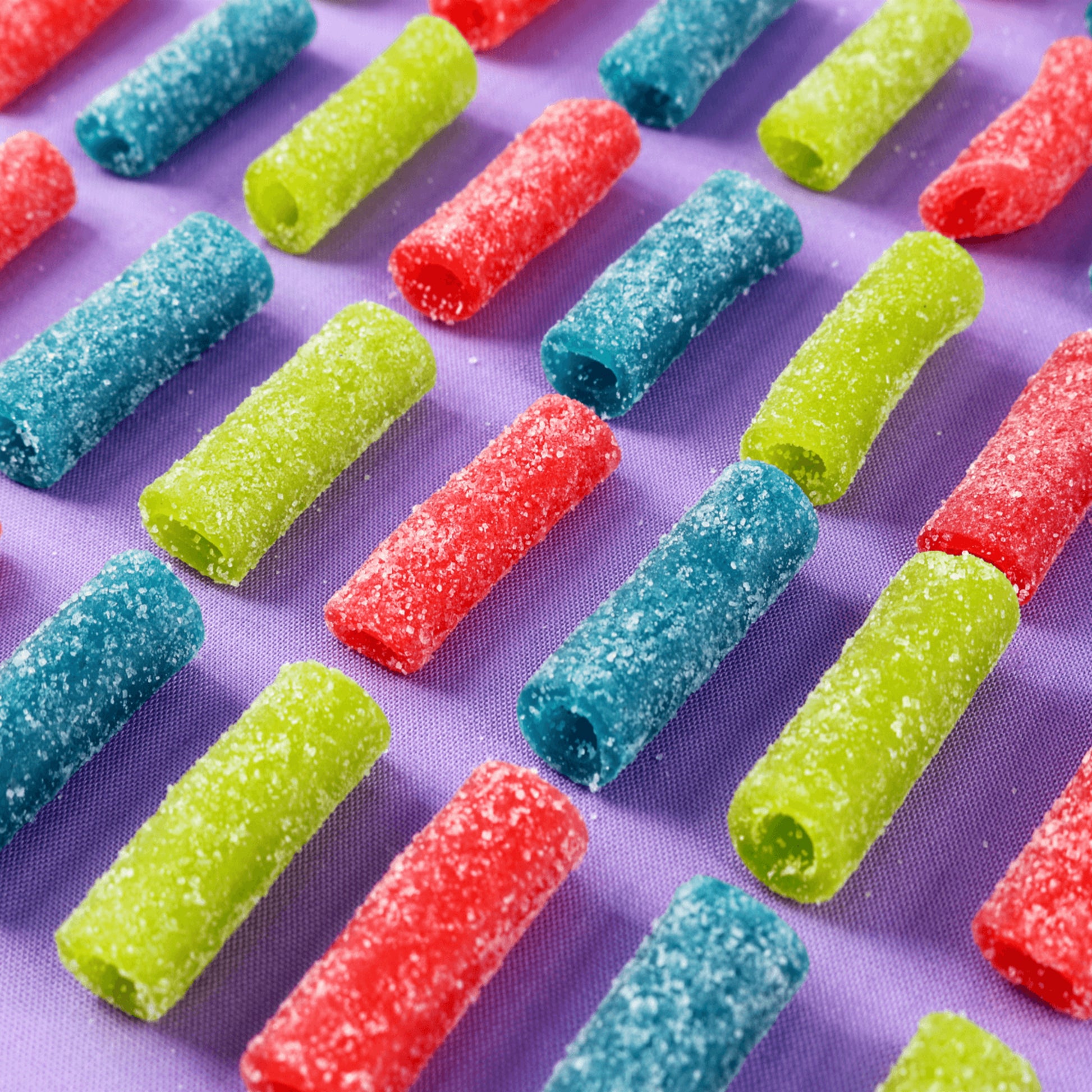 Sour Punch Bites Raw Candy on Purple Background - Assorted Sour Candy - Sour Punch Straw Bites
