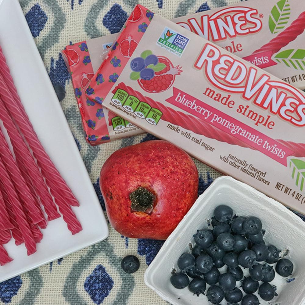 RED VINES Made Simple Blueberry Pomegranate Twists 4oz Trays along side fresh fruit and licorice twists