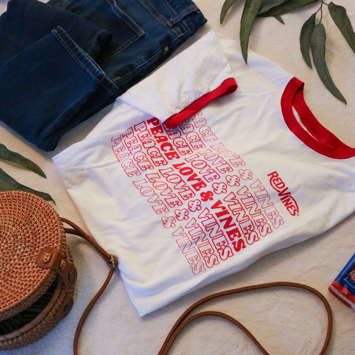 RED VINES Red and White Peace, Love & Vines T-Shirt with blue jeans and a wicker purse