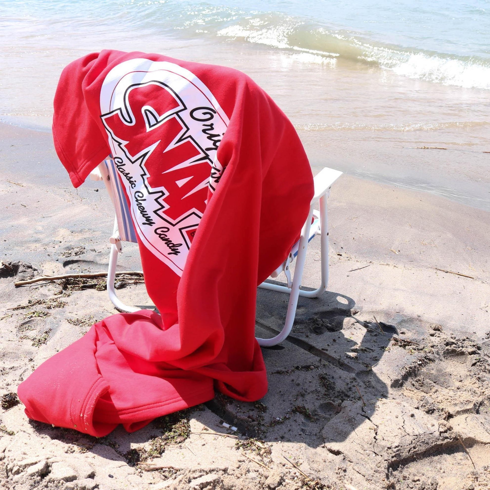 SNAPS Blanket draped across a lawn chair at the beach