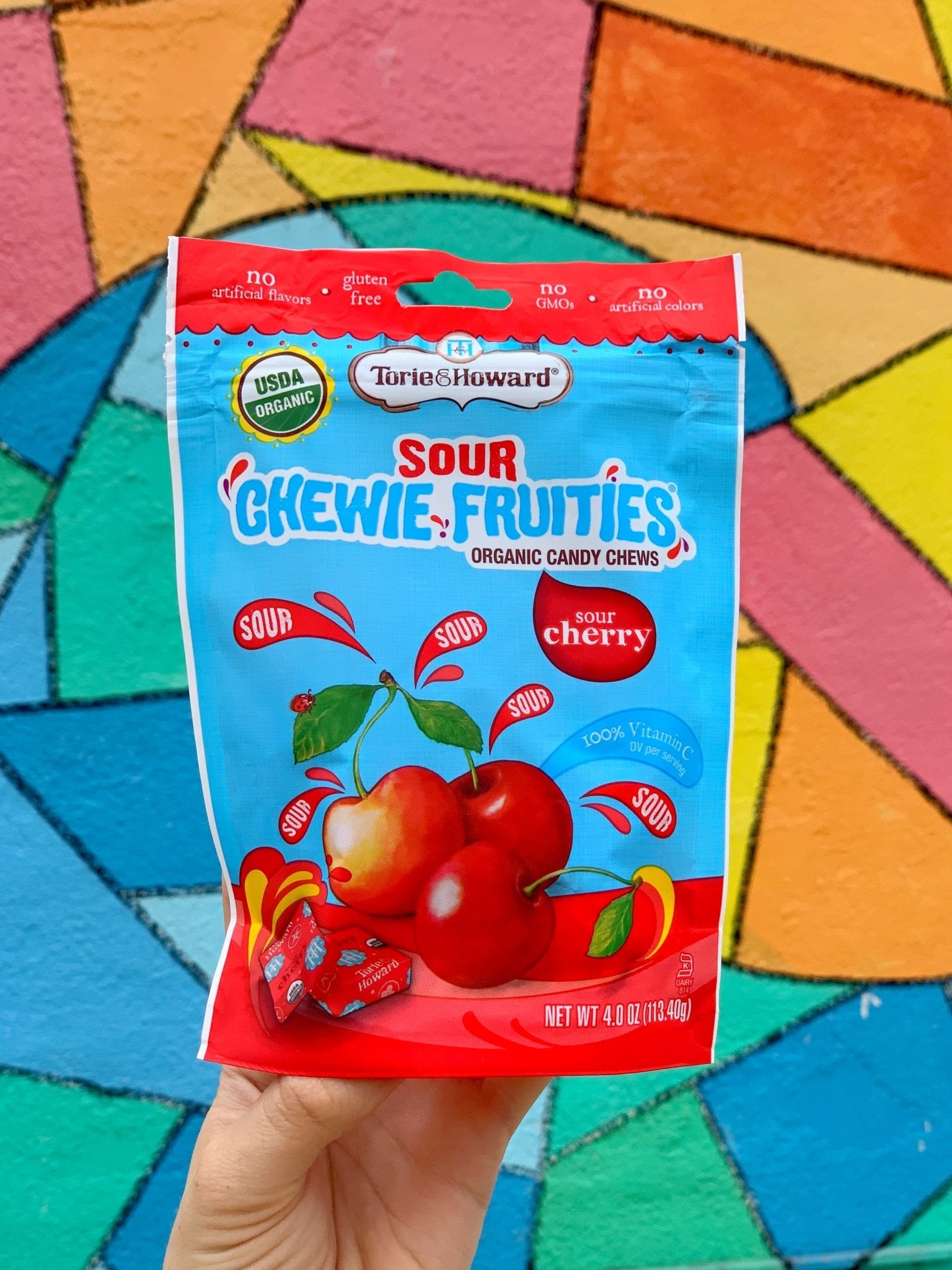 Torie & Howard Chewie Fruities Sour Cherry Candy, 4oz Bag in front of a colorful mosaic background